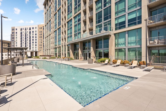 view of swimming pool with pool water feature and a patio area