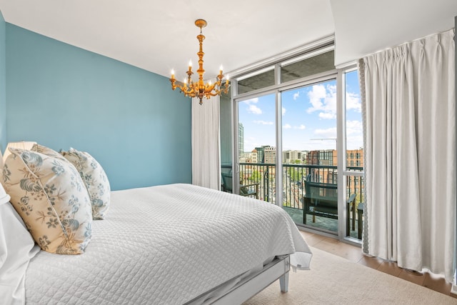 bedroom with an inviting chandelier, floor to ceiling windows, access to outside, and light wood-type flooring