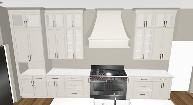 kitchen featuring premium range hood, white cabinets, double oven range, and hardwood / wood-style floors