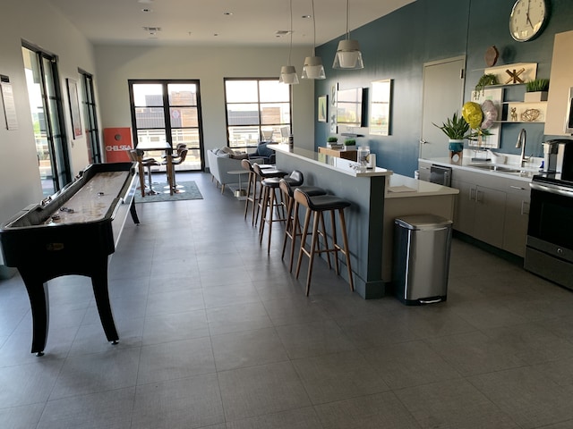 1900 12th Ave S Unit 313, Nashville, TN 37203 - kitchen featuring white cabinets, hanging light fixtures, a breakfast bar area, sink, and tile floors