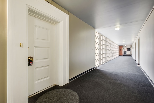 hallway with dark colored carpet