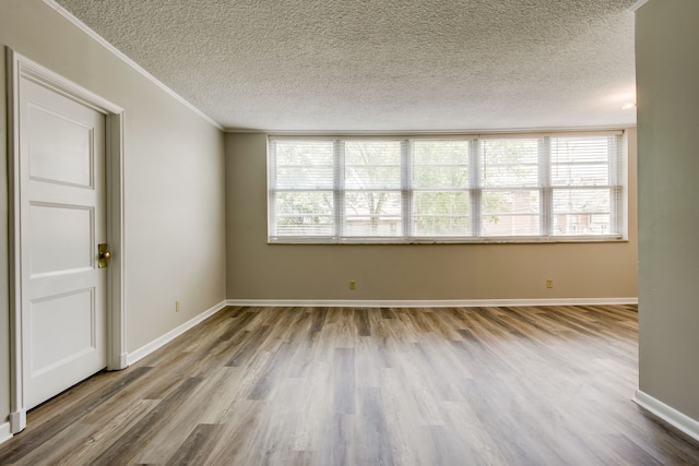 empty room featuring a healthy amount of sunlight, a textured ceiling, and wood-type flooring