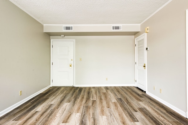 empty room with a textured ceiling and dark hardwood / wood-style floors