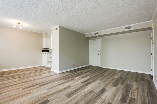 unfurnished living room featuring ornamental molding, hardwood / wood-style floors, and a textured ceiling