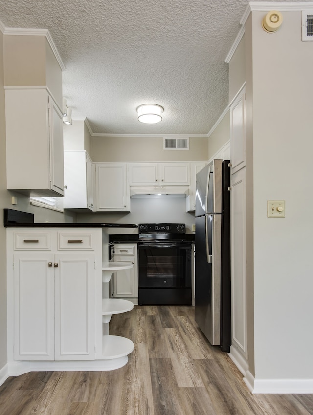 kitchen with hardwood / wood-style flooring, stainless steel refrigerator, black / electric stove, and white cabinetry