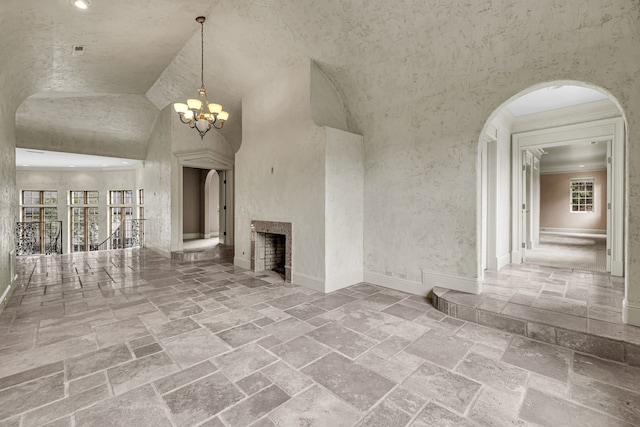 unfurnished living room featuring high vaulted ceiling and an inviting chandelier