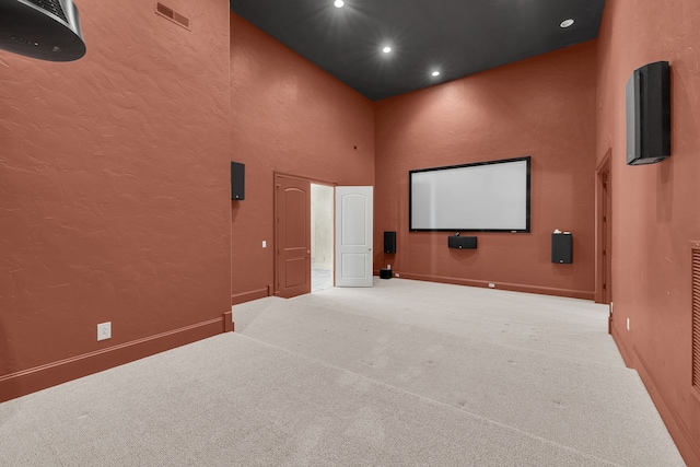 home theater featuring carpet floors and a high ceiling