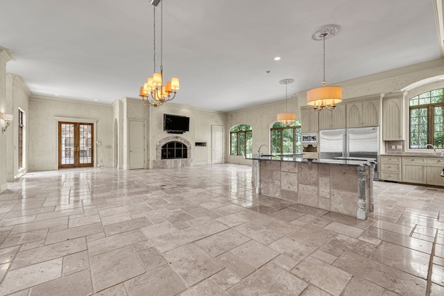 kitchen featuring decorative light fixtures, a tile fireplace, a notable chandelier, and built in appliances