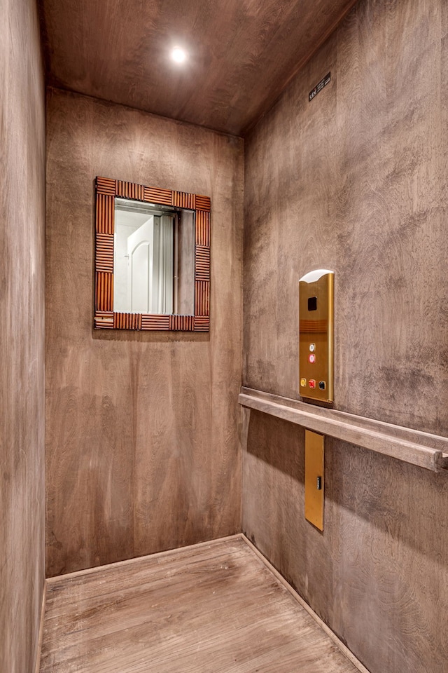 details featuring hardwood / wood-style floors and elevator