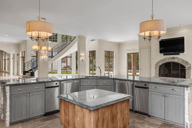 kitchen with an inviting chandelier, pendant lighting, gray cabinetry, and a center island