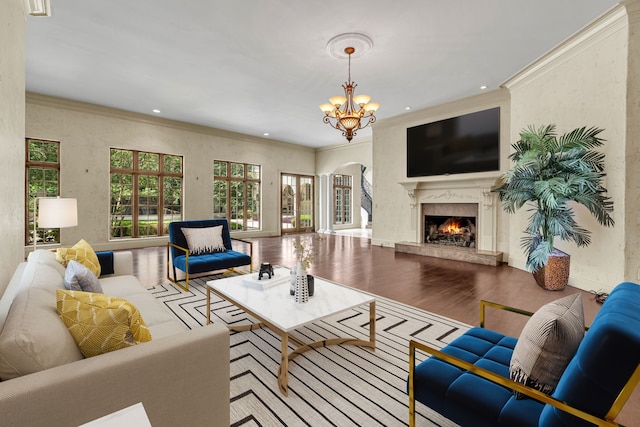 living room with a premium fireplace, ornamental molding, light hardwood / wood-style flooring, and a notable chandelier