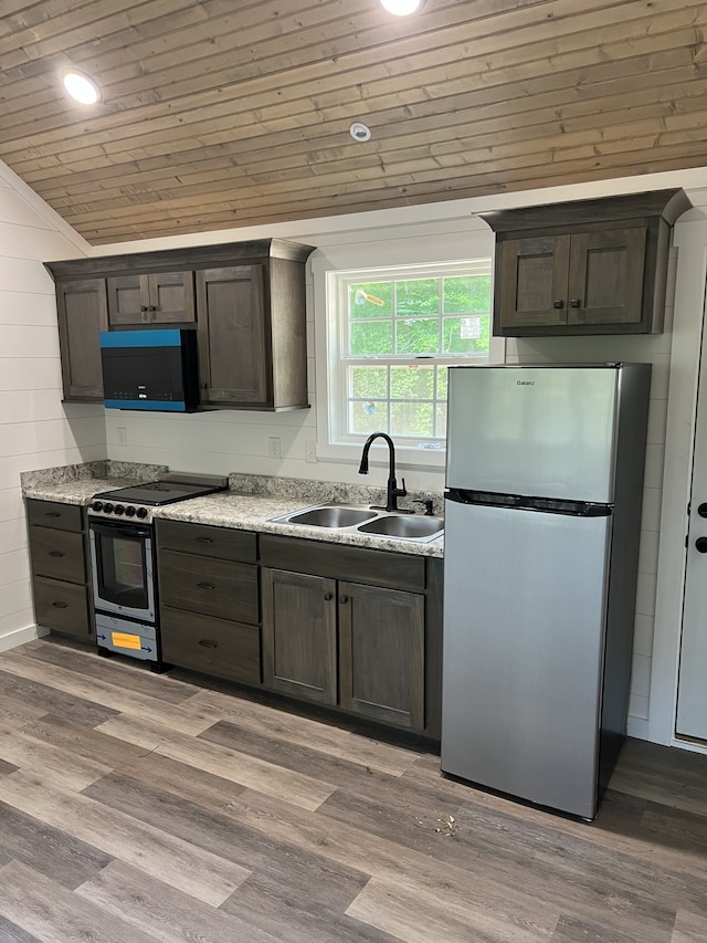 kitchen with stainless steel fridge, gas range, wood-type flooring, and sink