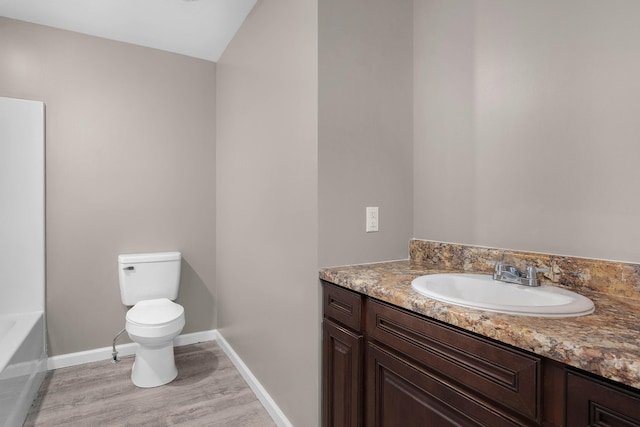 bathroom with wood-type flooring, toilet, and vanity