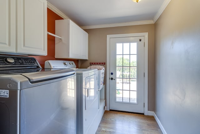 washroom with cabinets, light hardwood / wood-style floors, washer and dryer, and a healthy amount of sunlight