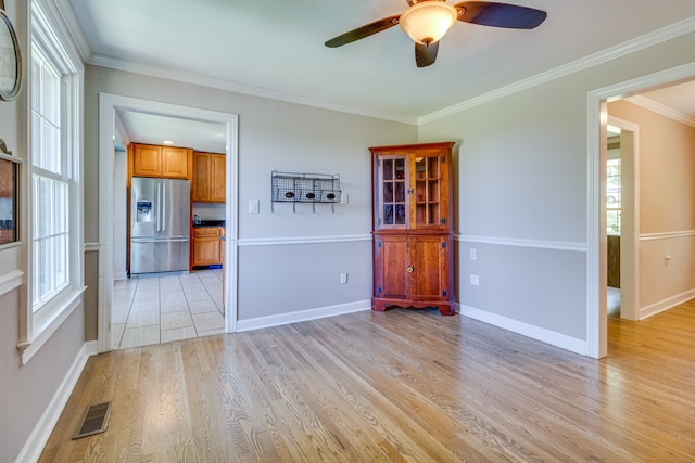 tiled empty room featuring crown molding and ceiling fan