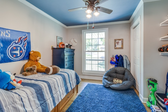 bedroom with a closet, ceiling fan, light wood-type flooring, and crown molding