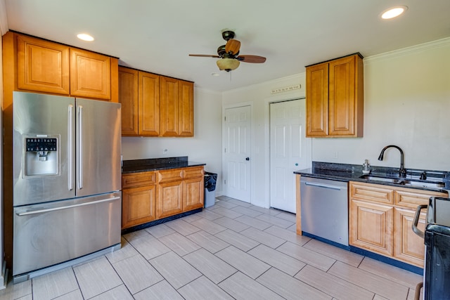 kitchen featuring dark stone counters, ceiling fan, ornamental molding, and stainless steel appliances