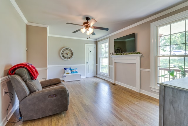 living room featuring crown molding, ceiling fan, and light hardwood / wood-style flooring