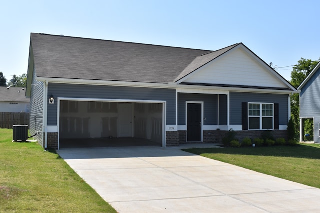 view of front of house featuring central AC, a front yard, and a garage