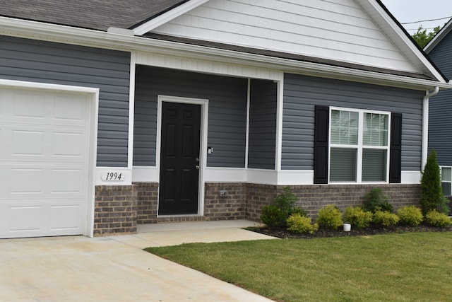 property entrance with a yard and a garage