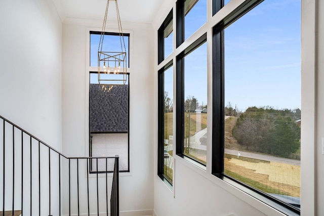 staircase with an inviting chandelier