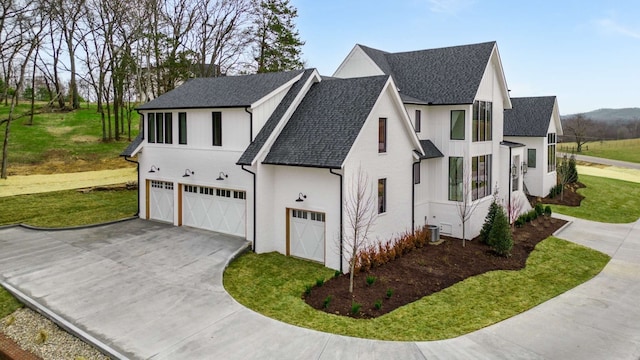 view of front facade with central AC, a front yard, and a garage