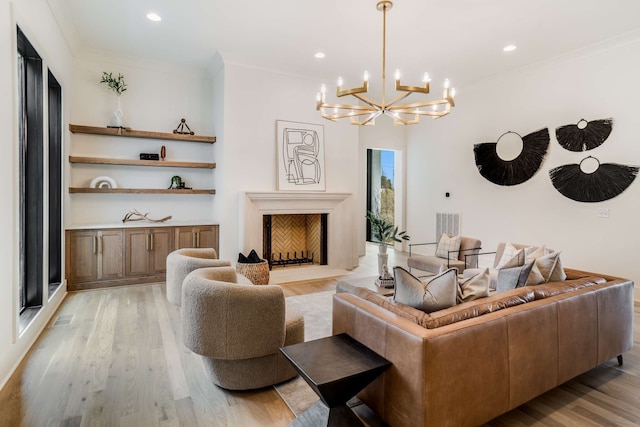 living room with light hardwood / wood-style floors, a notable chandelier, and crown molding