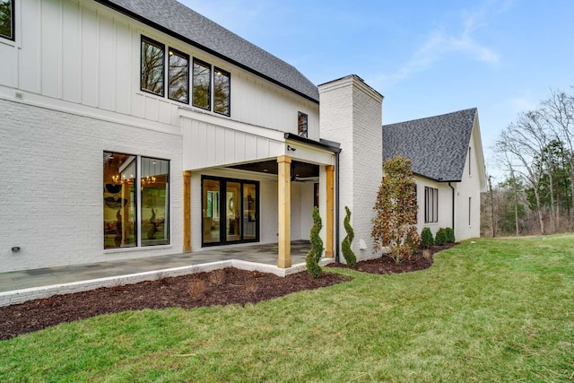 back of property with a yard and a patio