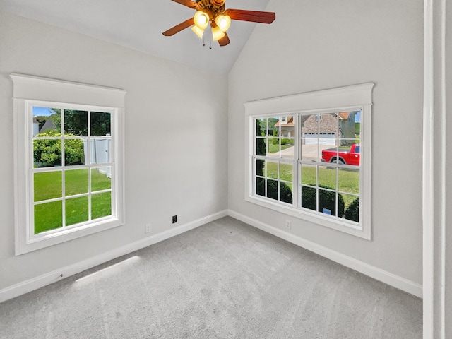 carpeted spare room with plenty of natural light, vaulted ceiling, and ceiling fan