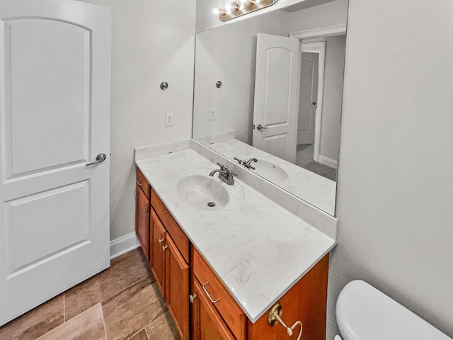 bathroom with toilet, vanity, and tile flooring