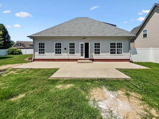 rear view of house with a patio and a lawn