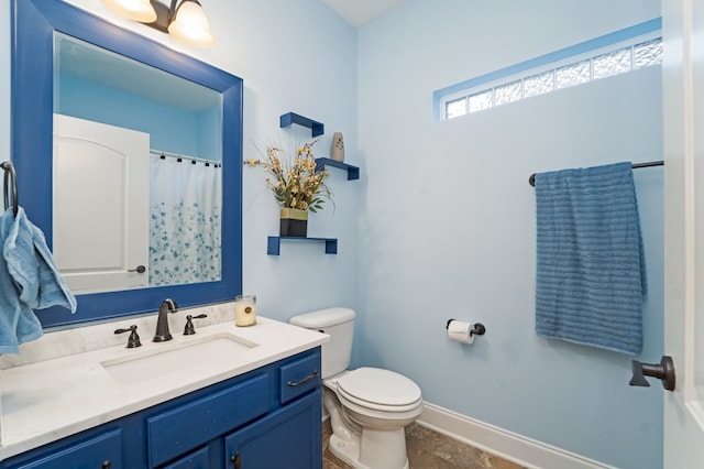 bathroom with tile flooring, vanity with extensive cabinet space, and toilet