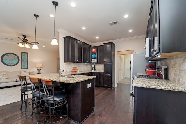 kitchen featuring backsplash, dark hardwood / wood-style floors, ceiling fan, and pendant lighting