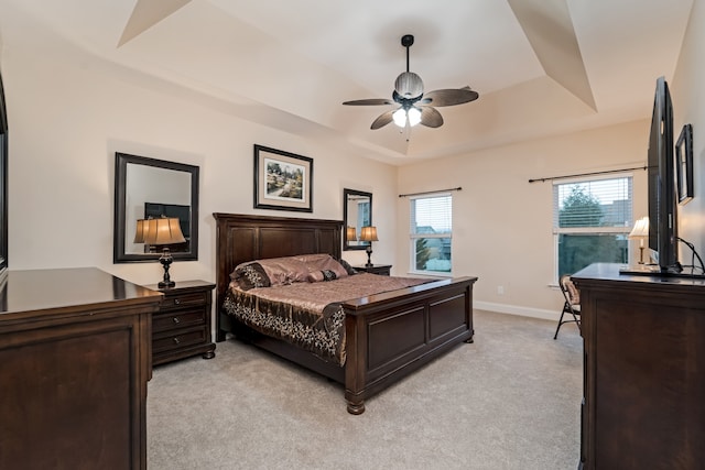 bedroom with a tray ceiling, ceiling fan, and light colored carpet