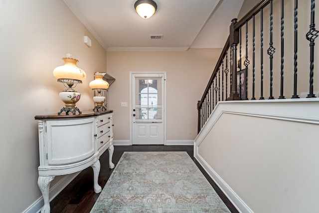 foyer entrance with dark wood-type flooring and ornamental molding