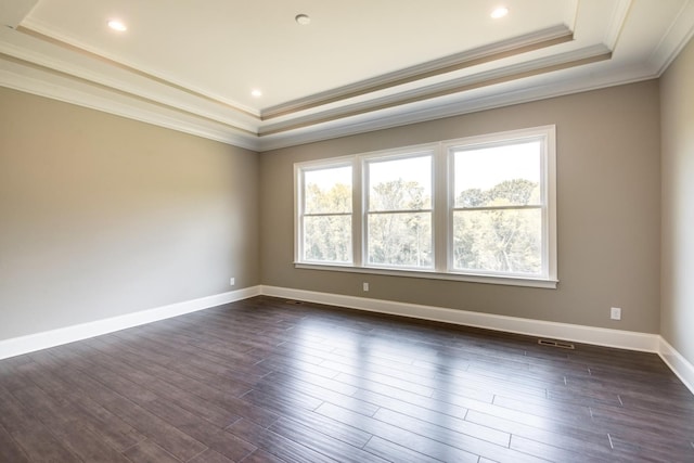 spare room with a raised ceiling, dark hardwood / wood-style floors, and crown molding