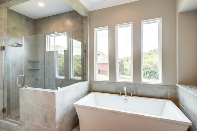 bathroom with tile walls and plus walk in shower