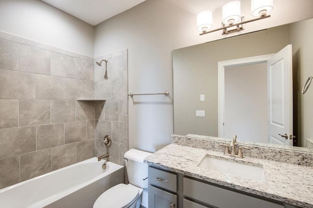 full bathroom featuring toilet, vanity, and tiled shower / bath combo