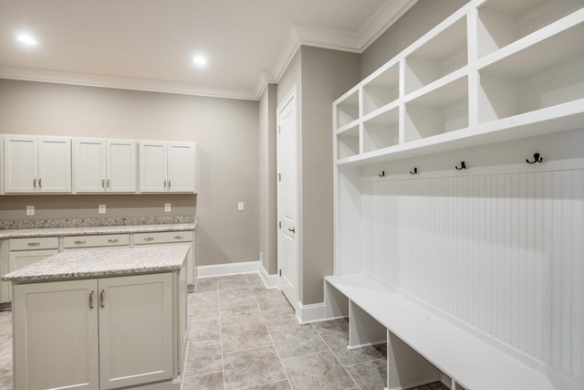 mudroom with crown molding and light tile floors