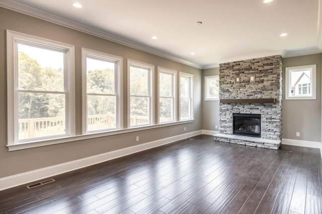 unfurnished living room with ornamental molding, a stone fireplace, and dark wood-type flooring