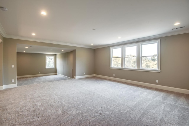 empty room with ornamental molding and light colored carpet