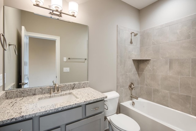 full bathroom featuring toilet, large vanity, and tiled shower / bath