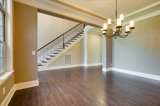 empty room with dark hardwood / wood-style flooring, crown molding, and a chandelier