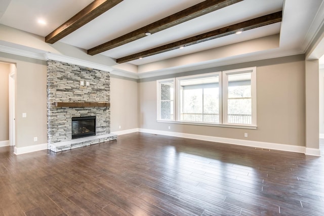 unfurnished living room with crown molding, a stone fireplace, dark hardwood / wood-style floors, and beamed ceiling