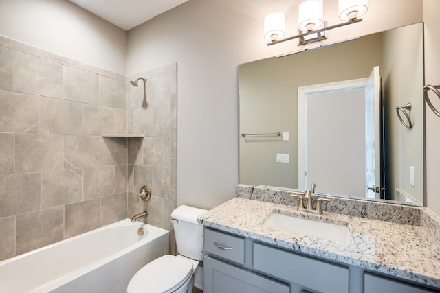 full bathroom featuring toilet, vanity with extensive cabinet space, and tiled shower / bath combo