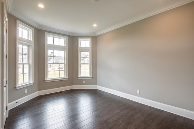 empty room featuring dark hardwood / wood-style flooring, crown molding, and plenty of natural light