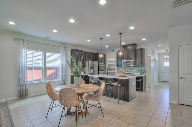 tiled dining area with sink and a notable chandelier