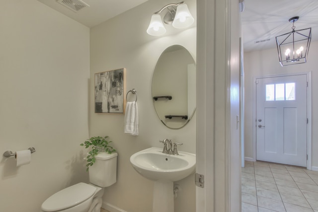 bathroom with an inviting chandelier, tile flooring, and toilet