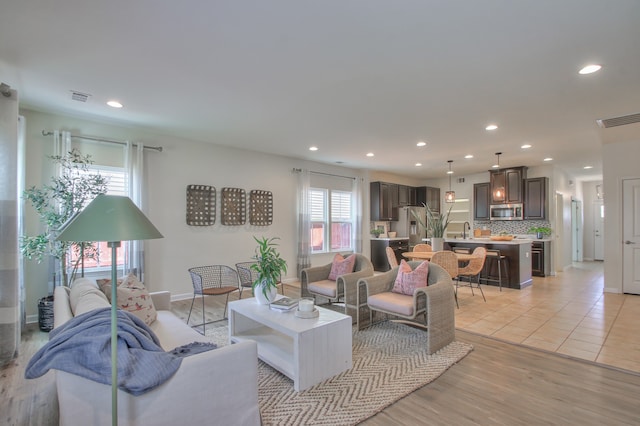 living room featuring sink and light hardwood / wood-style floors