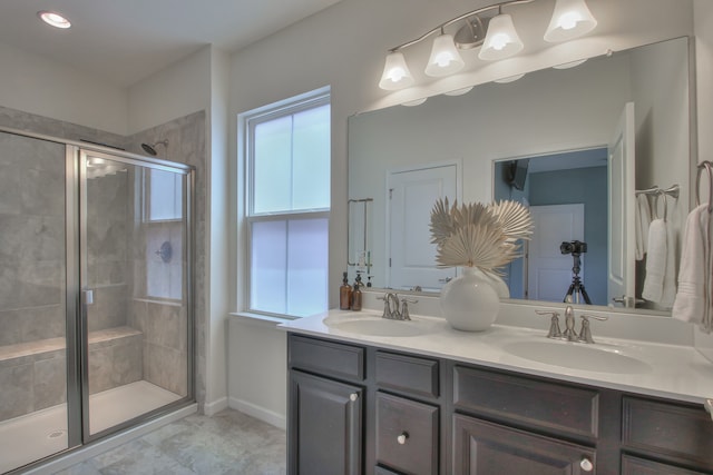 bathroom with tile flooring, dual sinks, a shower with door, and oversized vanity